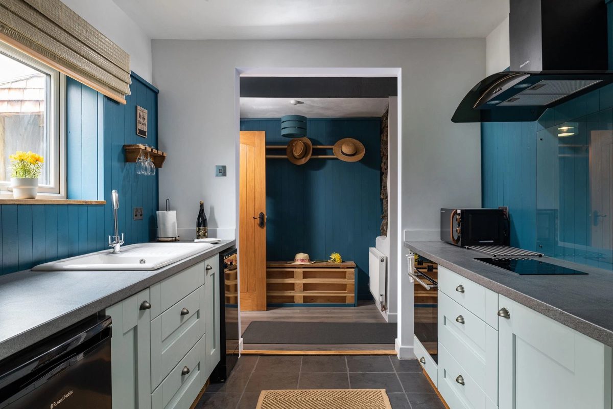 Willow cottage kitchen with hats hanging on hooks by the door